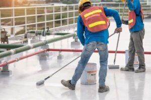 Two individuals engaged in cleaning a concrete surface, applying techniques to restore its cleanliness and appearance.