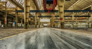 An empty warehouse featuring a long, unobstructed walkway extending into the distance.